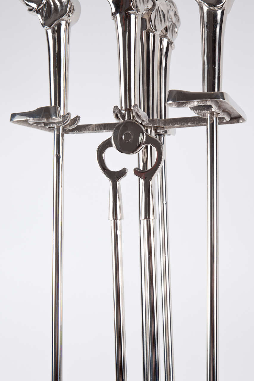 Fantastic set of Art Deco fireplace tools in polished nickel with stylized elephant head motif. Set includes stand, shovel, poker, broom, and tongs.