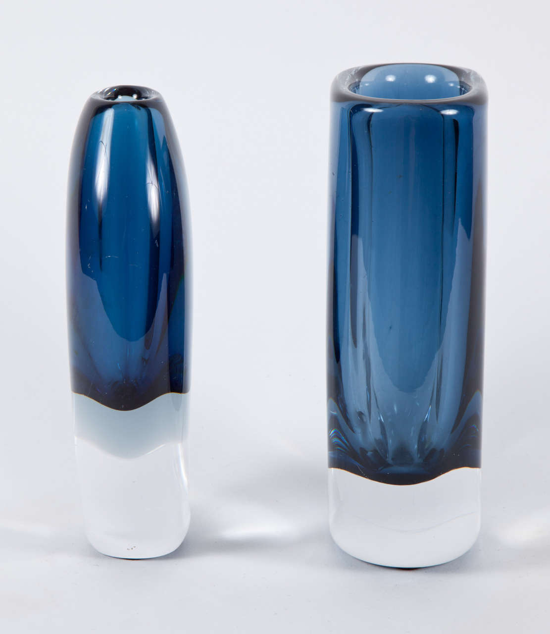 Fantastic set of 2 blue and clear glass vases by Vicke Lindstrand 1 for Orrefors the other for Kosta.

Oval measures 7.25