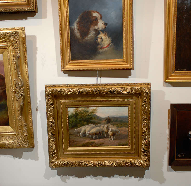 This 19th century Belgian, oil on canvas painting, set within an elegant carved giltwood frame, depicts a pastoral scene with a shepherd driving his flock at sunset, a crook in his hands. He is alone with his animals, the setting sun flooding the
