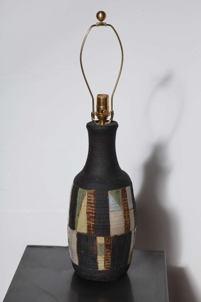 Handcrafted Italian Modern Art Studio Grey Ceramic Table Lamp with Glazed Colored Pattern.  Featuring a hand thrown Dark Charcoal Gray banded bottle form with reflective glazed triangular and rectangular geometrics highlighted in Pale Yellow, Green,