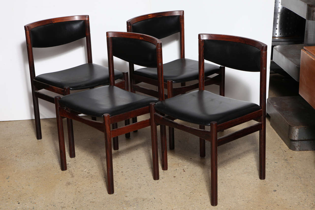 Set of four Danish modern SAX Soro Stolefabrik dark Brazilian rosewood and black vinyl chairs. Featuring a comfortable, beautifully grained, dark rosewood frame with black vinyl back and seat. Sturdy. Comfortable.