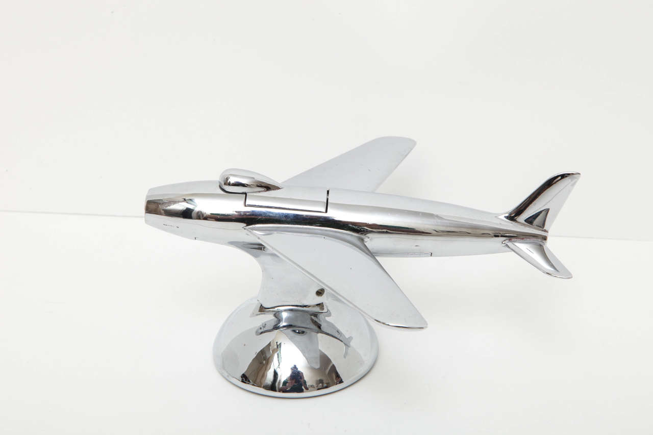 A Dunhill novelty table lighter in the form of an airplane. When the nose of the plane is depressed, the lighter mechanism pops up out of the cockpit. Signed Dunhill, Made in England. 
