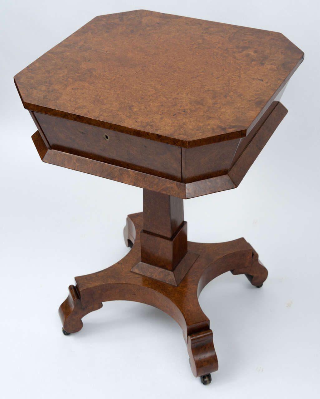 An excellent quality Late Regency amboyna sewing/occasional table.  The square top with wide canted corners, the tapering body with a frieze drawer, mahogany lined and incorporating a  mahogany sliding/lift out divided tray.  Raised on a square