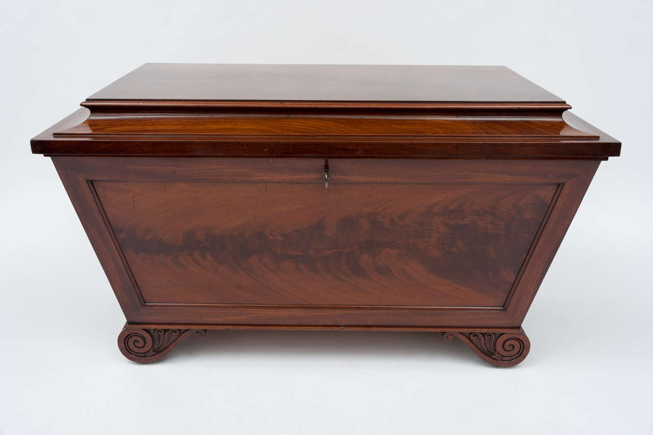 A good regency mahogany sarcophagus shaped wine cooler. The flat top with lovely figured mahogany. The front, back and side panels also with figured mahogany. Raised on carved scrolled feet. The timber of a good rich colour and patina. The interior