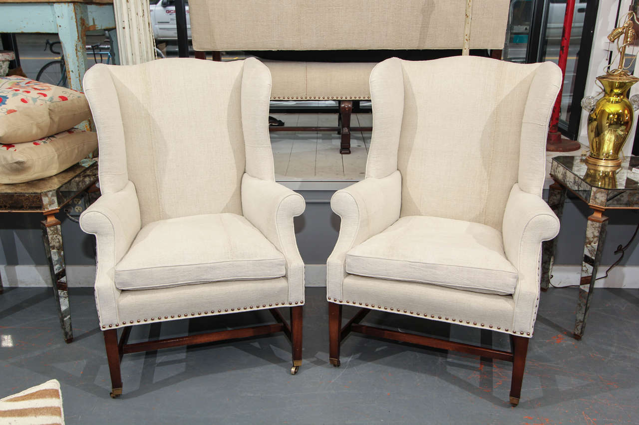 Small scale, very comfortable pair wing backs in heavy french linen.  Down cushions, nailhead trim, original casters .  Great lines, very handsome chairs.