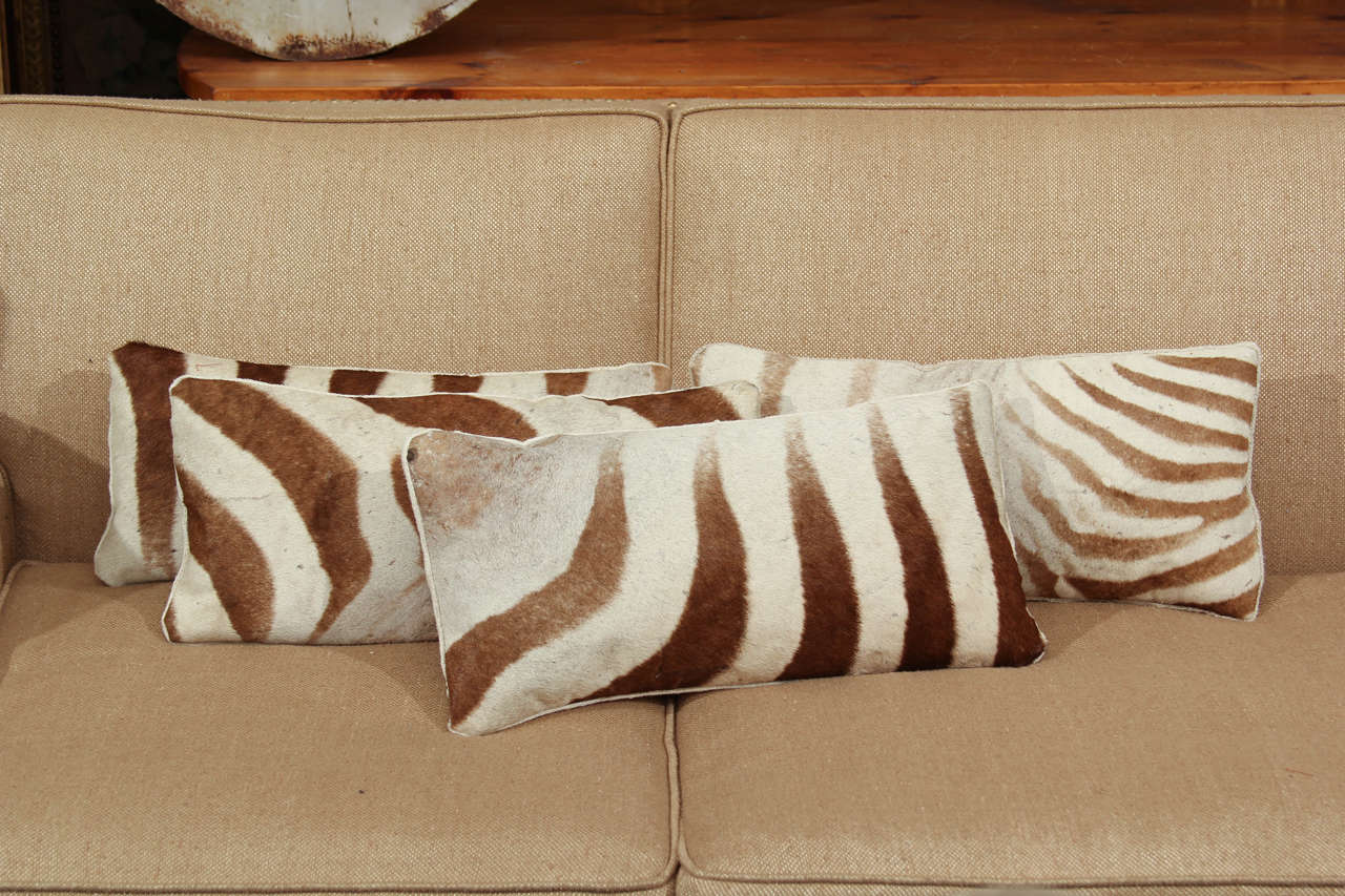 group of 4 pillows newly constructed  from vintage zebra hide backed in vintage french linen and flax.  feather inserts.   
4 available, priced individually