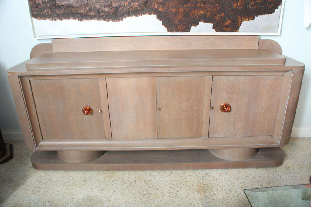 The stepped top over four doors fitted with shelves and drawers, with salmon glass pulls.