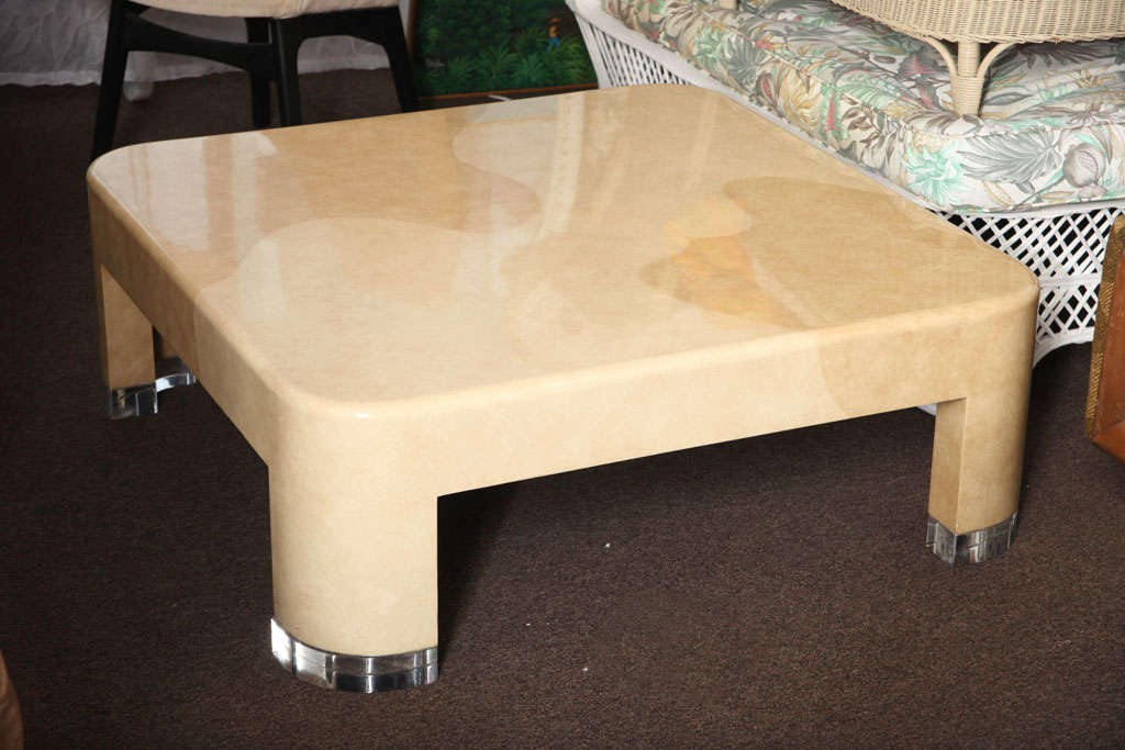 Rounded, gleaming surfaces dominate this large, two-tone coffee table. Formica is painted with faux-granite techniques with two tones predominating: Honey and almond. Each curved table leg rests on a thick Lucite base.