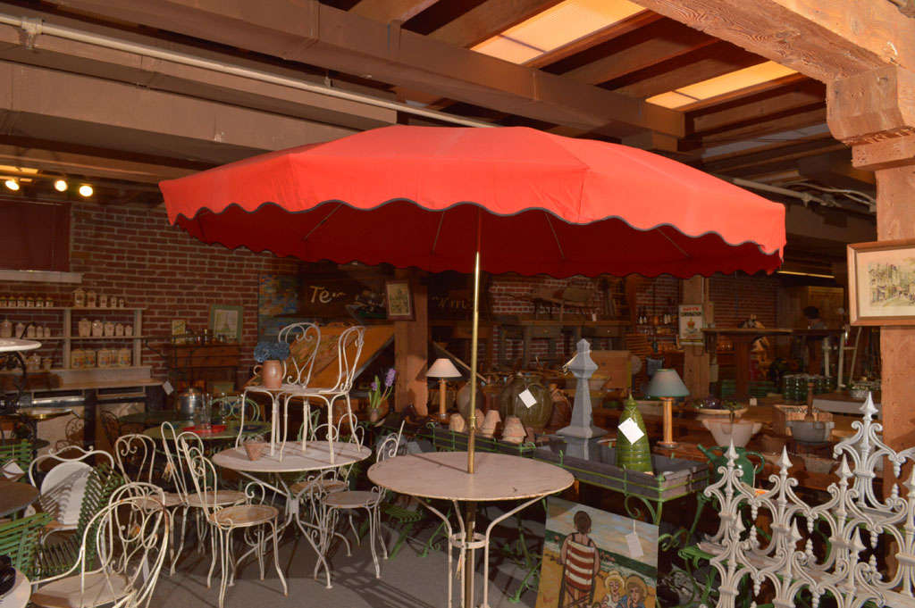 Vintage umbrella with original frame and a solid brass pole.  Fire red fabric (with black trim) replaced.