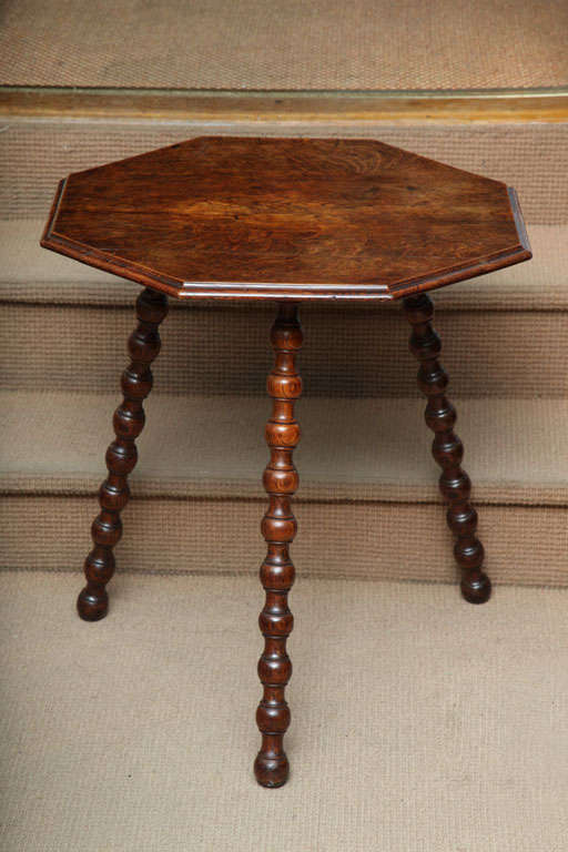 Fine English late 19th Century Oak octagonal table, the shaped and molded top with vivid quarter sawn oak, over finely turned bobbin and spool spayed legs.