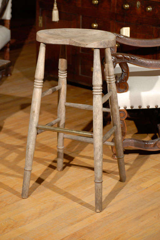 This English stool is unusual because of the weathered Elm. The Elm turned a gorgeous grey brown.  The stool is tall and has a wonderful shaped seat.  The English stool has turned legs and a brass foot rest.<br />
<br />
Please visit our website
