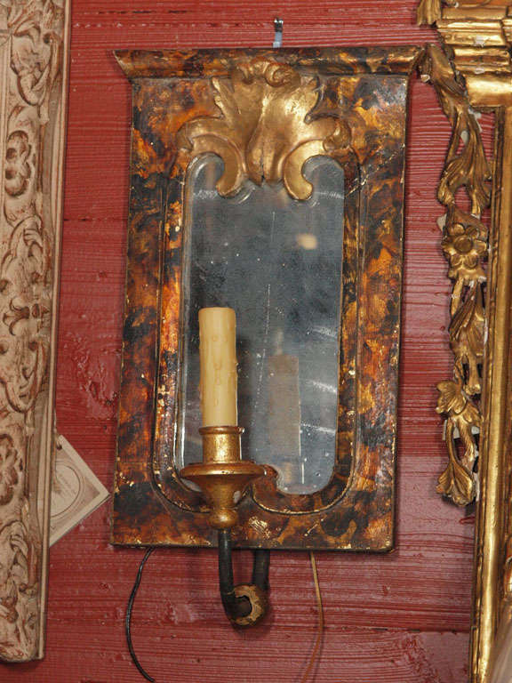 Pair of Italian one arm mirrored sconces.  Backplate is a faux tortoise shell with a gilded shell like motif at the crown.