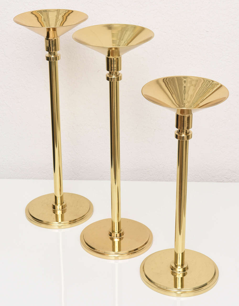 Trio of polished brass vintage candlesticks in different sizes.  Shorter single candlestick measures 12