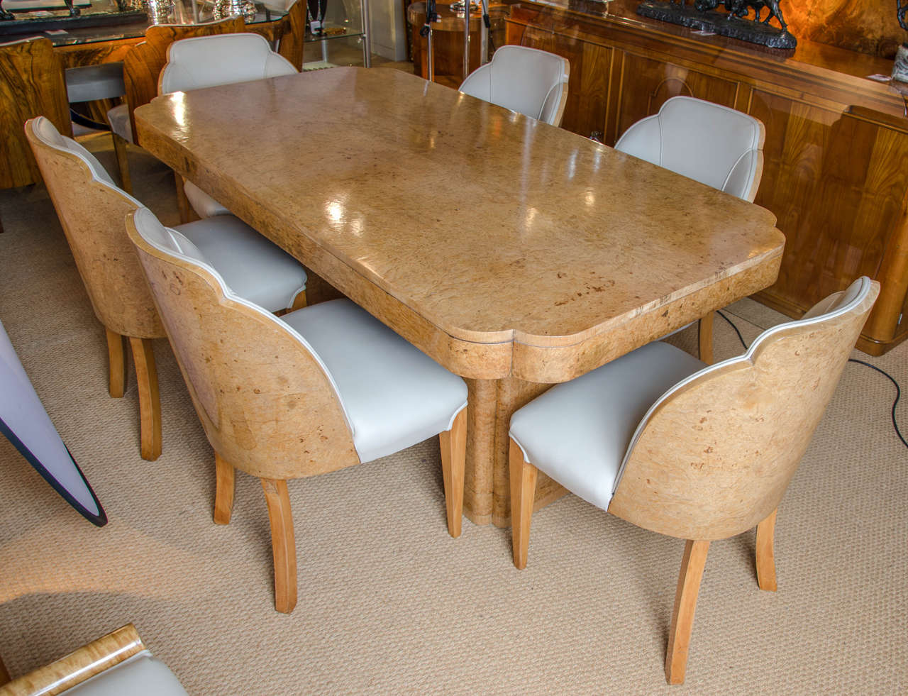 An Art Deco cloud dining suite by Harry and Lou Epstein. Figured walnut table set on two pedestal legs and six leather upholstered, walnut backed chairs.

Table dimensions: H 77.5cm, L 183cm, W 91.5cm.

Chairs dimensions: H 85.5cm, W 52.5cm,