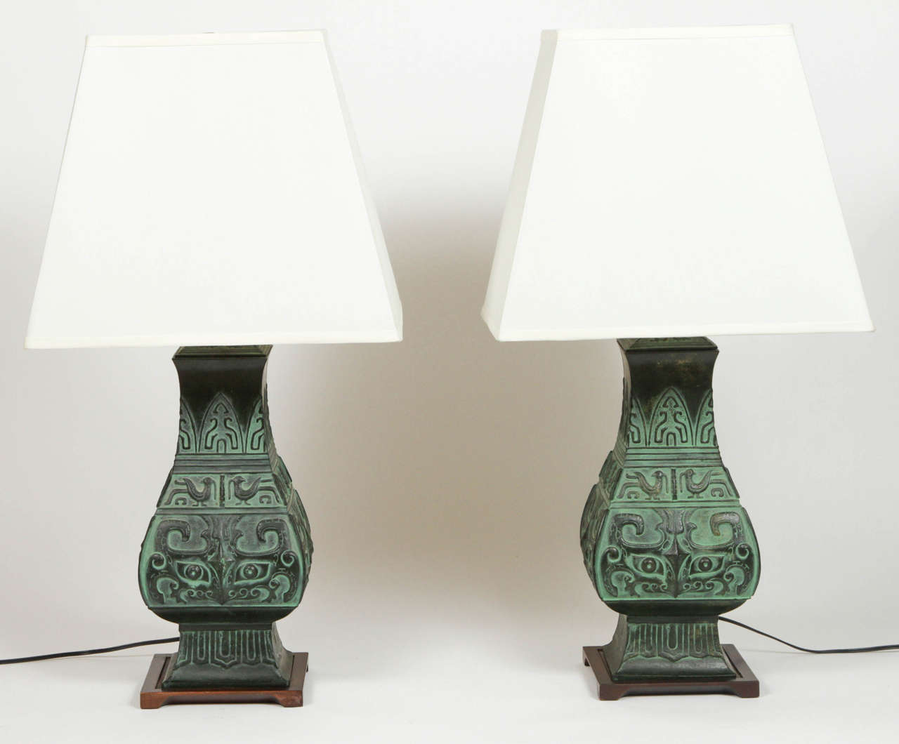 Pair of Archaic Chinese lamps with new silk shades. 
Shades measure 16 wide x 12 deep x 13.5 high (at widest point). 
Wood base.