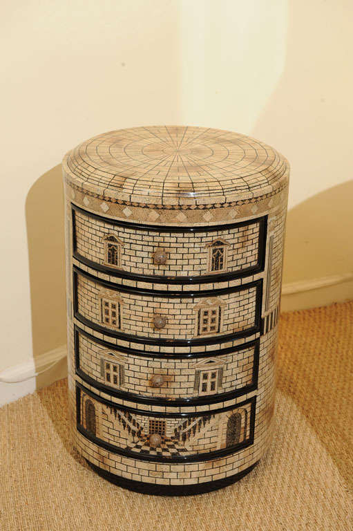 A small Fornasetti style 4-drawer chest decorated and lacquered with an intricate architectural motif.