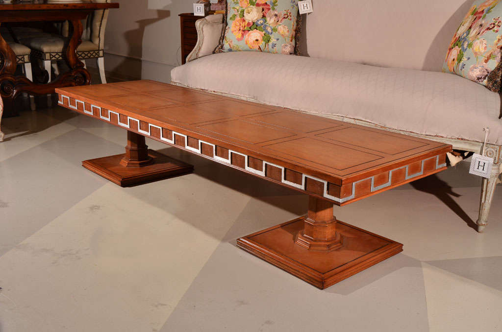 Coffee Table / Low Table in the manner of Robsjohn-Gibbings,
with double pedestal base, framed inset top, and crenelated silver leaf detail to apron