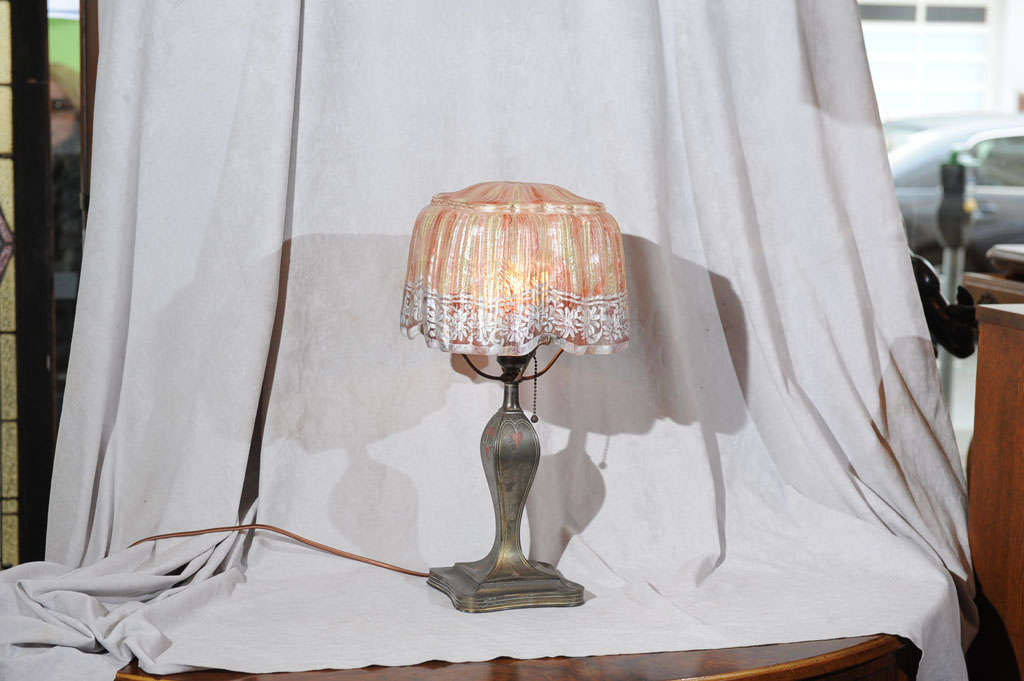 A very nice example of the work of the well known Pairpoint Corp. This nice little lamp has the desired closed top and has the lovely drapery glass. The base is signed and is nicely styled.