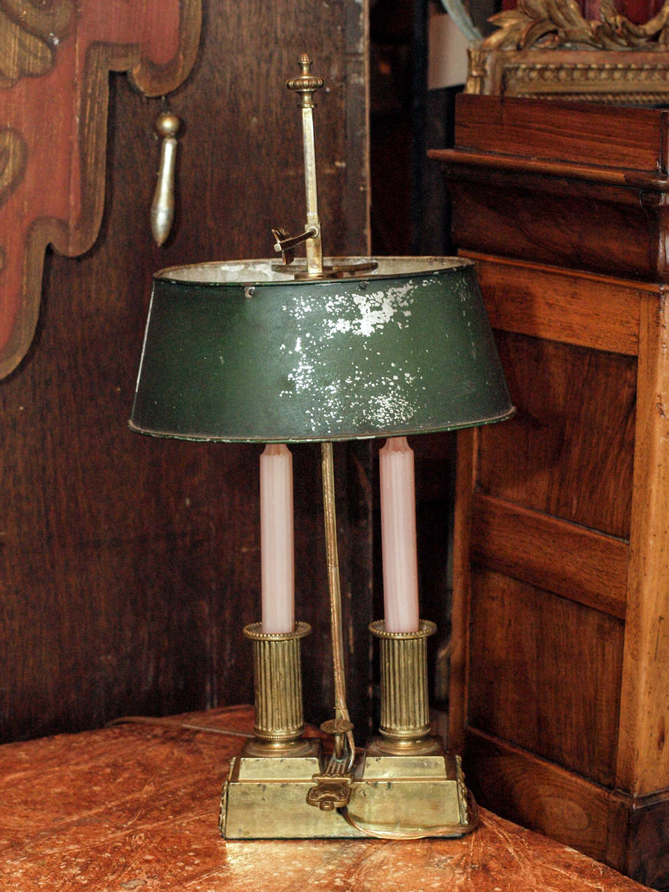 Mid 19th century French bronze bouillotte lamp with oval tole shade with a rectangular base with swags on 3 sides, 2 fluted columns for candles, and carrying handle. US wired with 2 candelabra lights inside the oval shade.