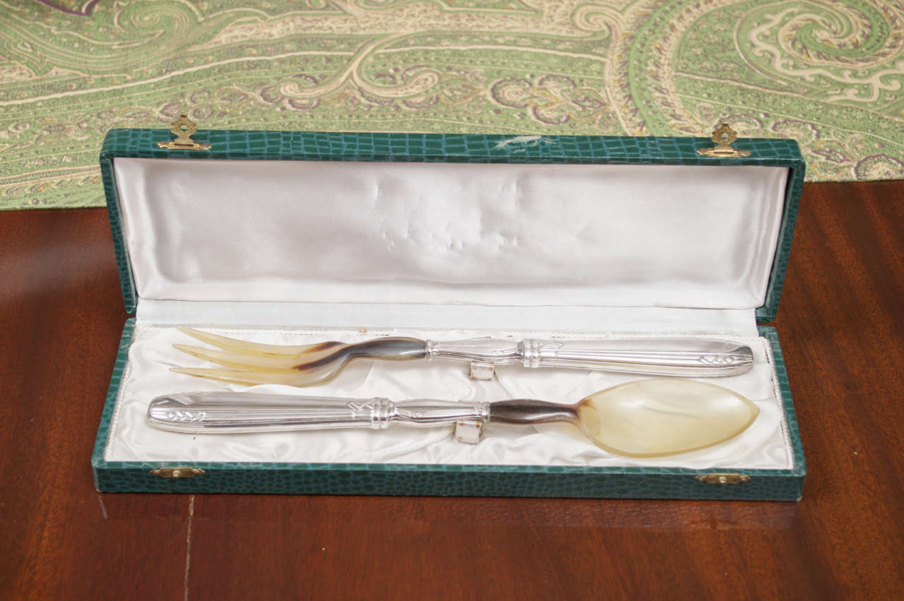 Two- piece set consisting of fork and spoon in iconic Art Deco style with celluloid tines and bowl mounted on silver handles in fitted green 