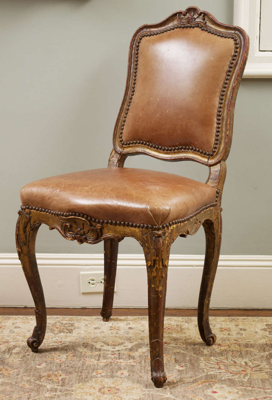 The central shell-crest surmounting a carved and molded backrest over a shaped seat above a scalloped seat rail raised on cabriole legs.  Covered in studded leather.  