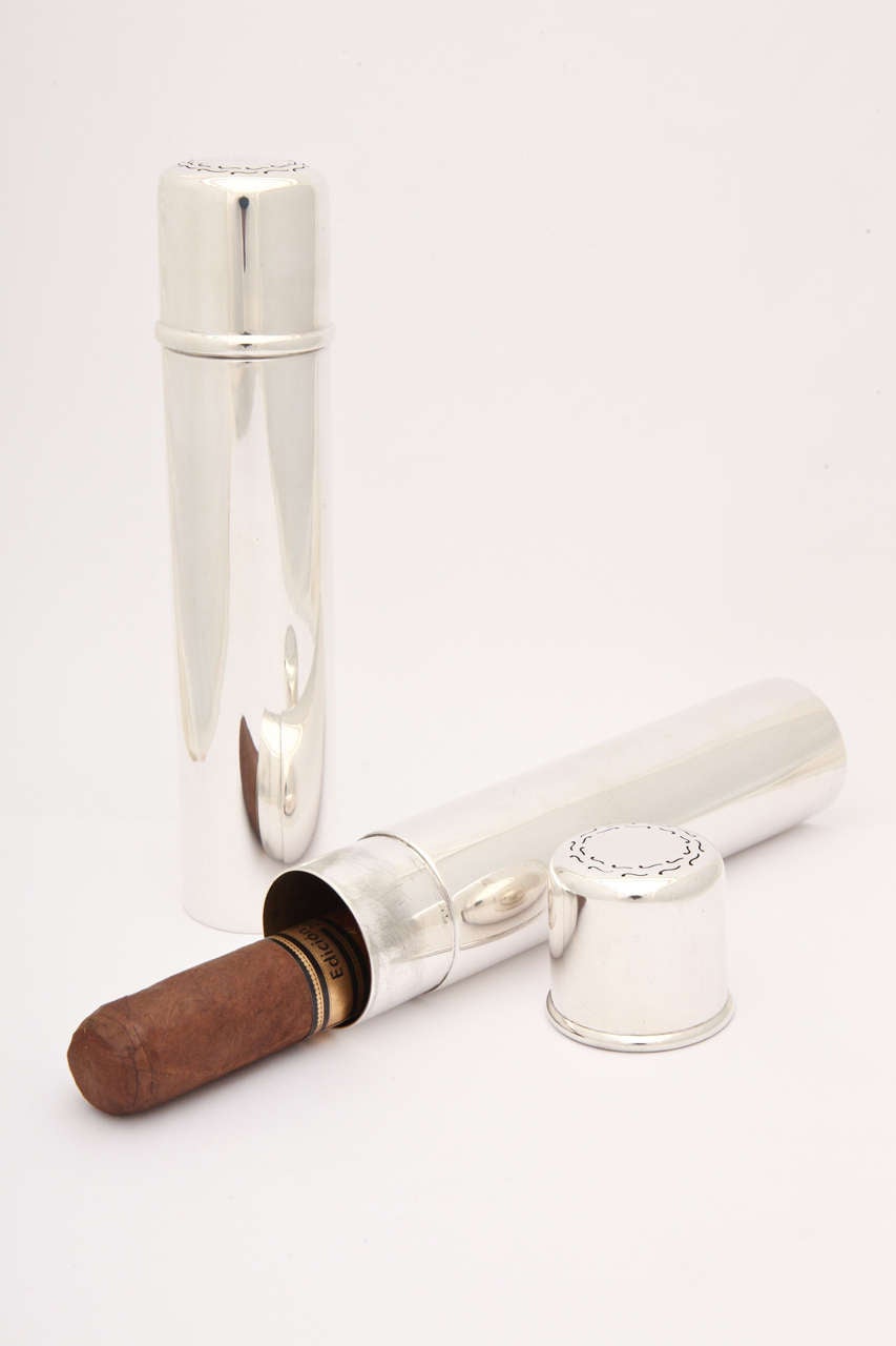 A beautiful pair of matching sterling silver cigar tubes by Tiffany & Co. Nice size fits larger, modern cigars. They are simply designed and free of engraving. Each lid has a decorative perforated border in a flourish design.  One could fit a small