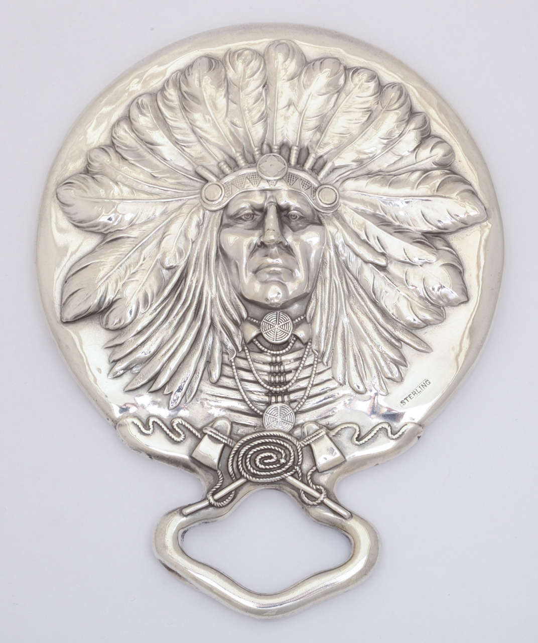 A superb Native American sterling silver shaving mirror by Unger Brothers. This highly detailed piece depicts an Indian Chief in full headdress. Made of sterling silver in a high relief pattern. The definition and detail is superb and demonstrates