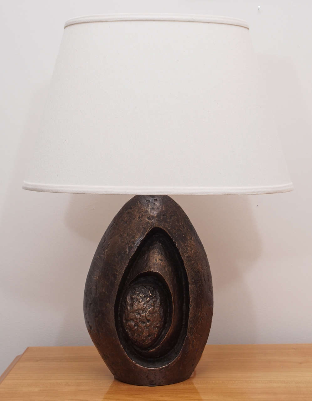 One sculptural table lamp in cast bronze with custom linen shade; signed 