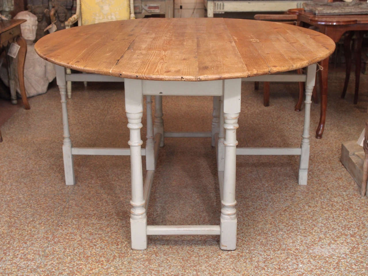 A 19th century drop leaf table with natural pine top and gray painted base.
Table is 17