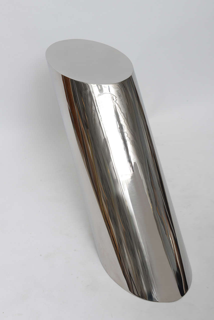 Sublimely simple polished stainless steel Zephyr table by J. Wade Beam for Brueton. Its heavily weighted base allows it to angle precipitously without tipping over.