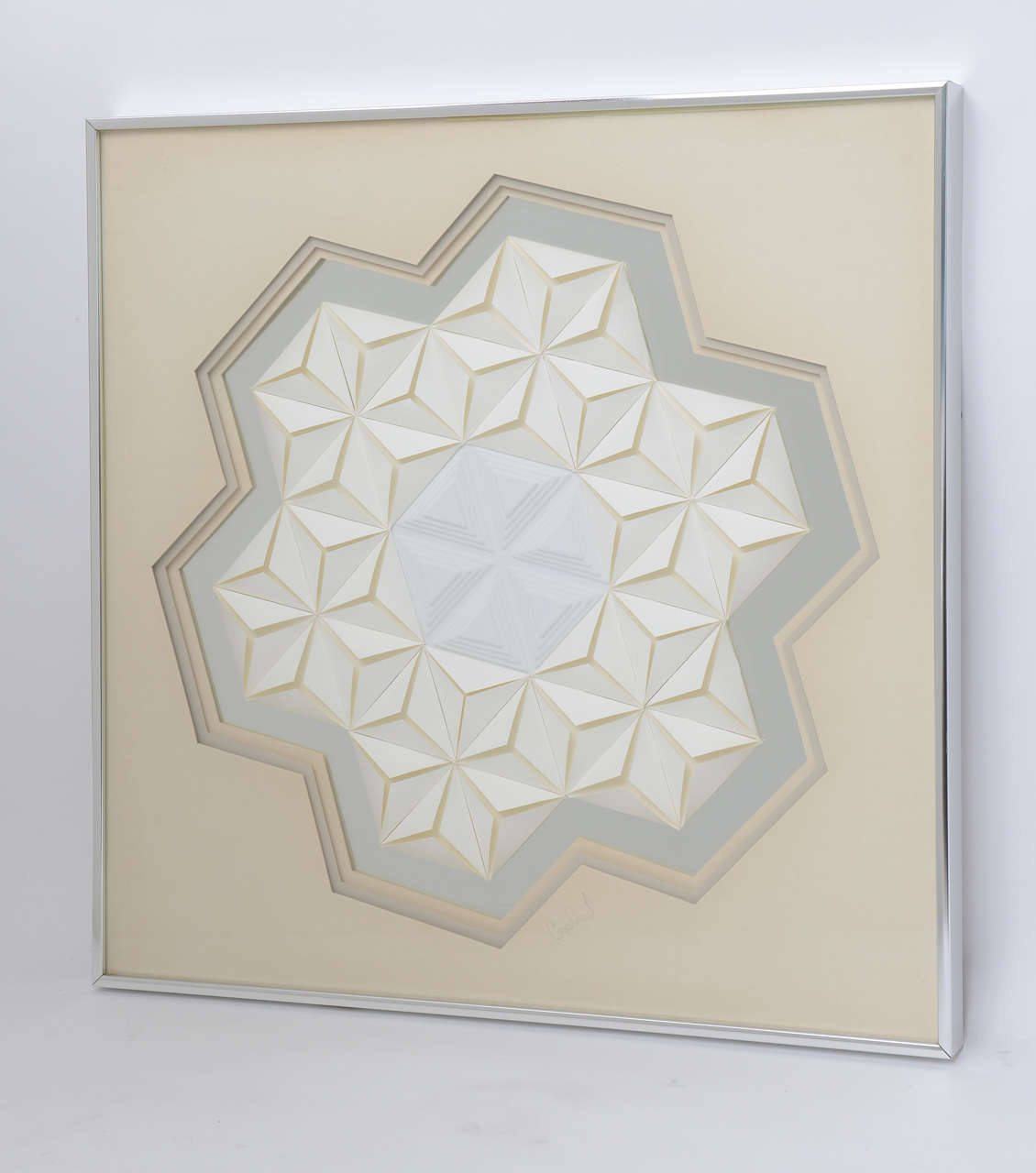 All our favorite colors combine in this mixed media wall sculpture by Greg Copeland. Off-white, folded paper patterns surround a dimensional white molded plastic center, with cream and grey matting on a reflective silver background. Tonal bliss!
