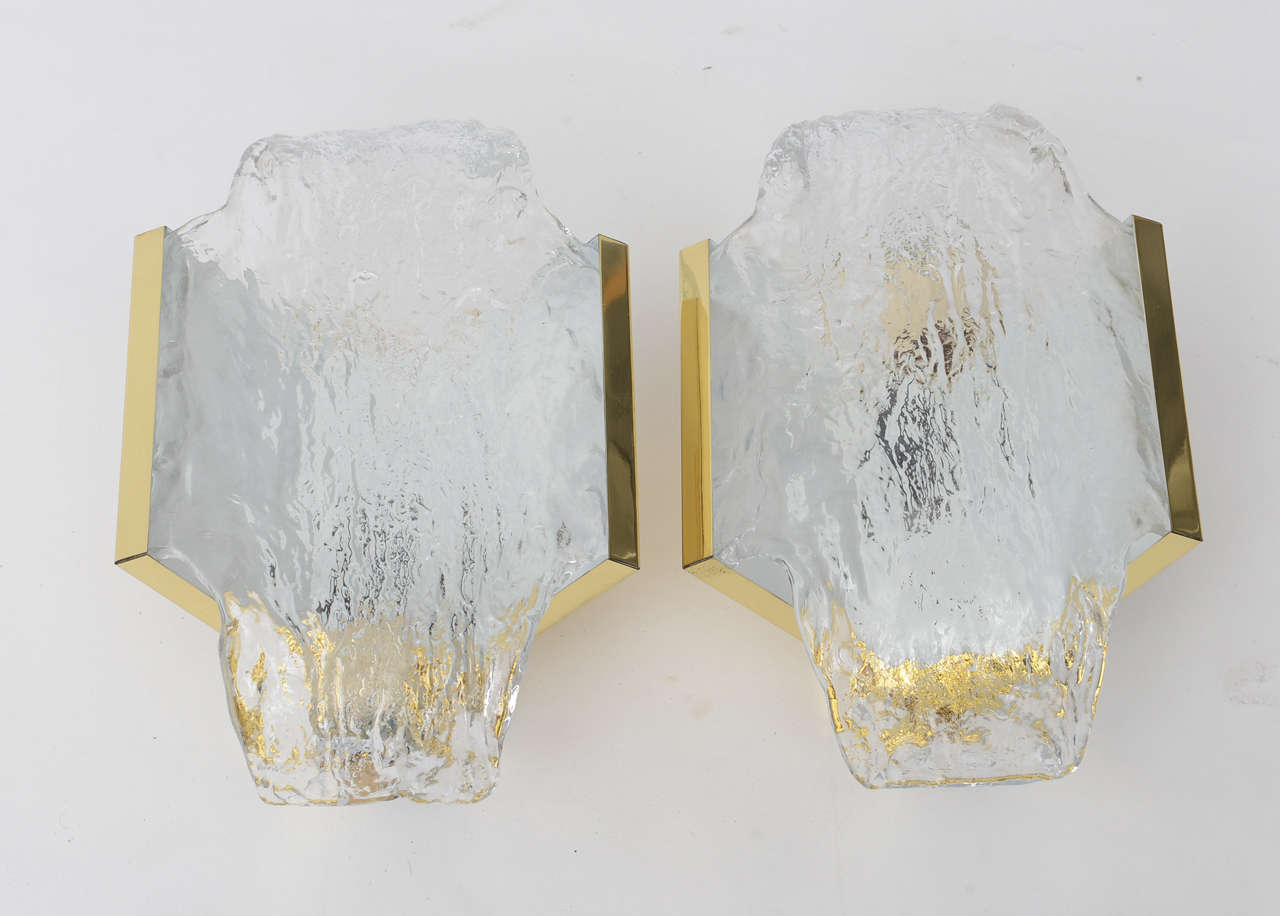 Handsome pair of 1960s Italian wall sconces by Mazzega with textured glass panels, tension mounted to V-form polished brass bases. Completely restored and re-wired for U.S. Sold by the pair, three pairs available.