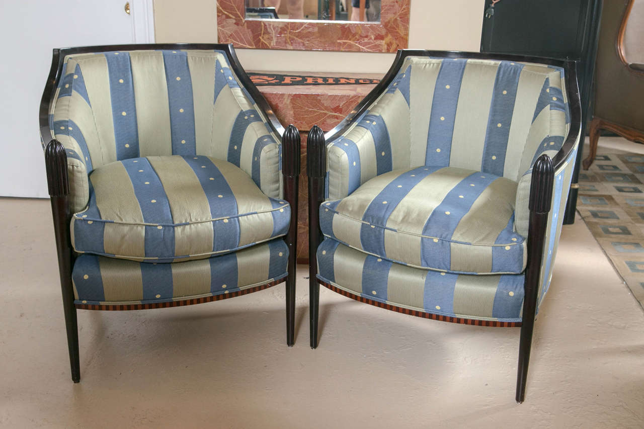 Pair of rosewood Art Deco barrel back chairs by Baker. A finely upholstered pair of ebonized and rosewood chairs in the Art Deco taste. These wonderfully upholstered chairs have ebonized frames with ebony and rosewood checkerboard design. This pair