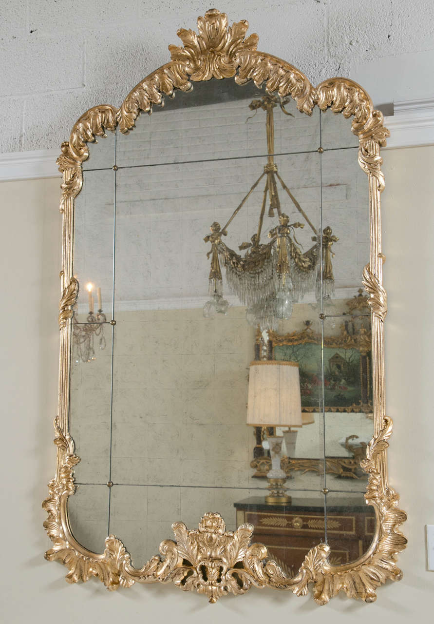 Pair of giltwood carved monumental console mirrors. A pair with lovely design and magnificent presence. Beauty at it's best! This is truly an exquisite pair of mirrors that will be stunning in any room! Wonderfully shell carved frames surround this