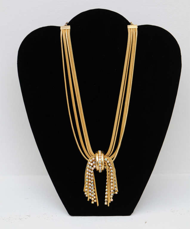 Four strand gold tone mesh Schiaparelli necklace. Dangling knotted tassel with iridescent rhinestones. Signed plaque, see image 9.
Reduced from $500.