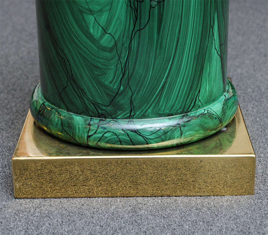 Quite sleek & Classic with it's square plinth brass bass and lush faux malachite finish, this Italian table with thick glass circular top is just lovely. Channeling Fornasetti, the illusion & trompe l'oeil of the painted and lacquered malachite is