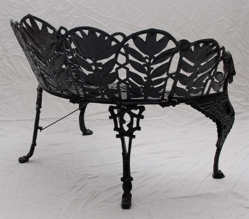 Very unique crescent shape garden set with back panels of laurel leaves and berries, open metal seat and winged griffen form legs. Recently stripped, zinc coated and painted

View our complete collection at www.hollisandknight.com