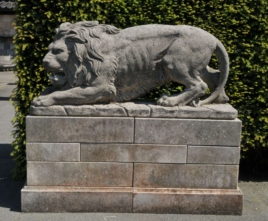 20th Century A lareg pair of French sculpted limestone models of lions on plinths