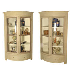 A pair of half round shaped corner cupboards