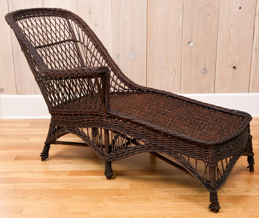 Antique wicker willow chaise in dark, natural finish.