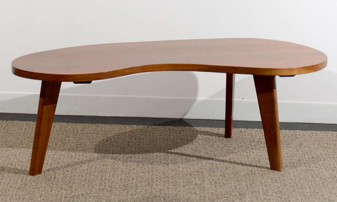 Superb amoeba coffee table in walnut. While the table is unmarked, it is reminiscent of Gibbings/Widdicomb tables of the early 1950's. The grain of the walnut shows beautiful movement. Excellent Restored Condition.TOM ROBINSON MODERN at TRAVIS &