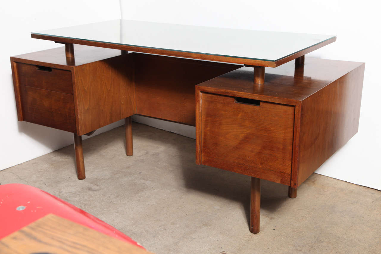 circa 1965 Milo Baughman Executive Walnut Desk with branded stamp by Glenn of California.  Featuring a classic California Modern design with floating top double pedestal Walnut veneer, rectangular Glass top, round dowel legs, rear built in bookcase,