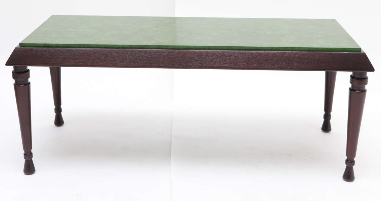 A beautiful mahogany cocktail table by William Haines that was designed for the Beverly Hills home of Armand & Harriet Deutsch. This model with its turned legs and faux painted green tabletop are signature Haines.