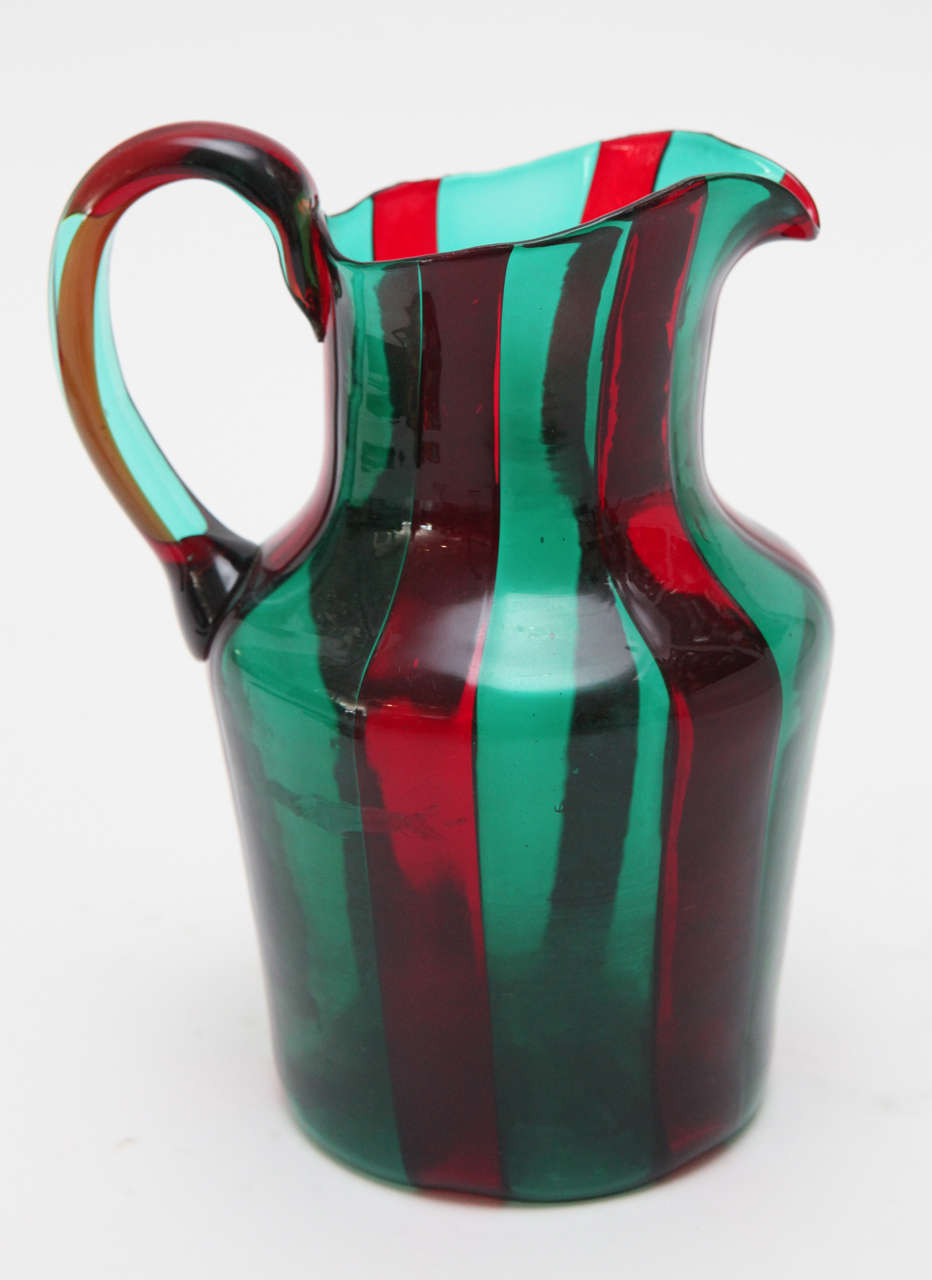 A vibrant red and green striped Murano glass pitcher by Fulvio Bianconi for Venini. Signed with the three-line Venini Murano Italia signature on the bottom.