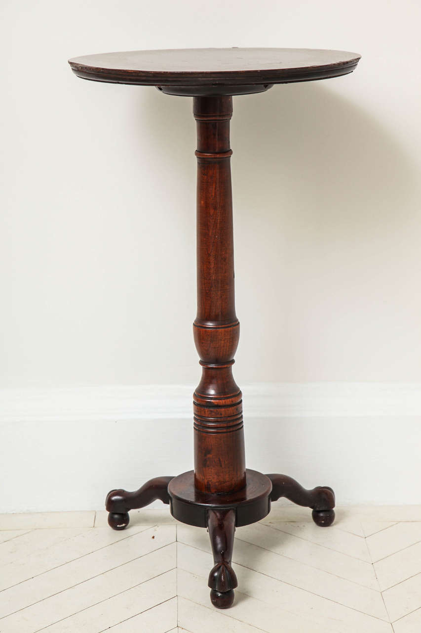 An English Regency mahogany pedestal table with turned baluster support and unusual tripartite base