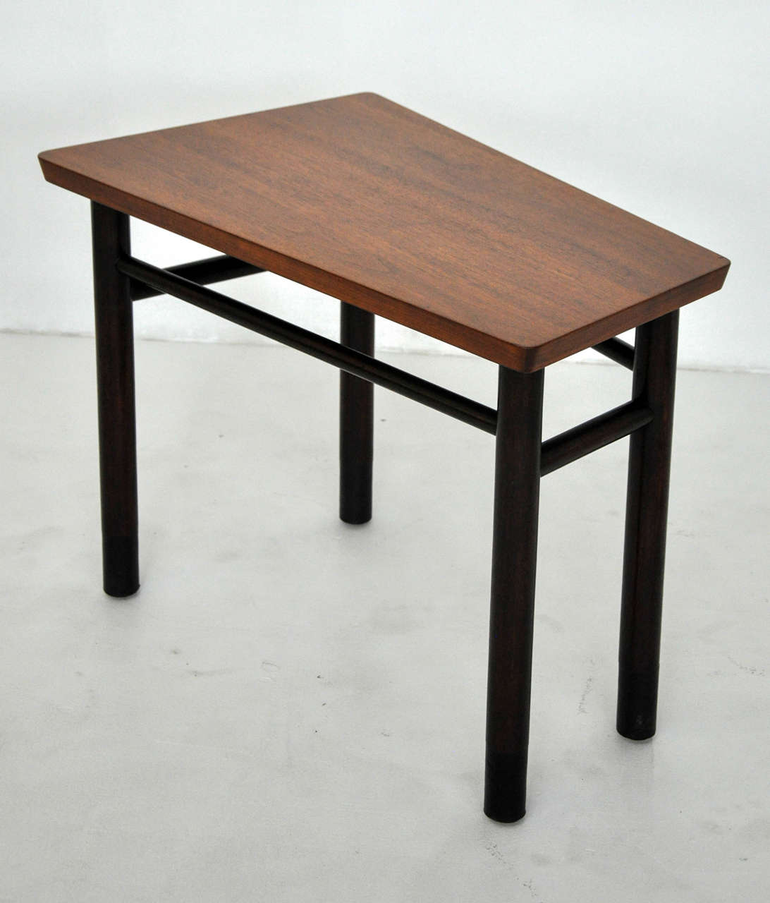 Trapezoid shaped end table designed by Edward Wormley for Dunbar, circa 1950s. Dark mahogany frame with walnut top. Excellent condition, refinished top.