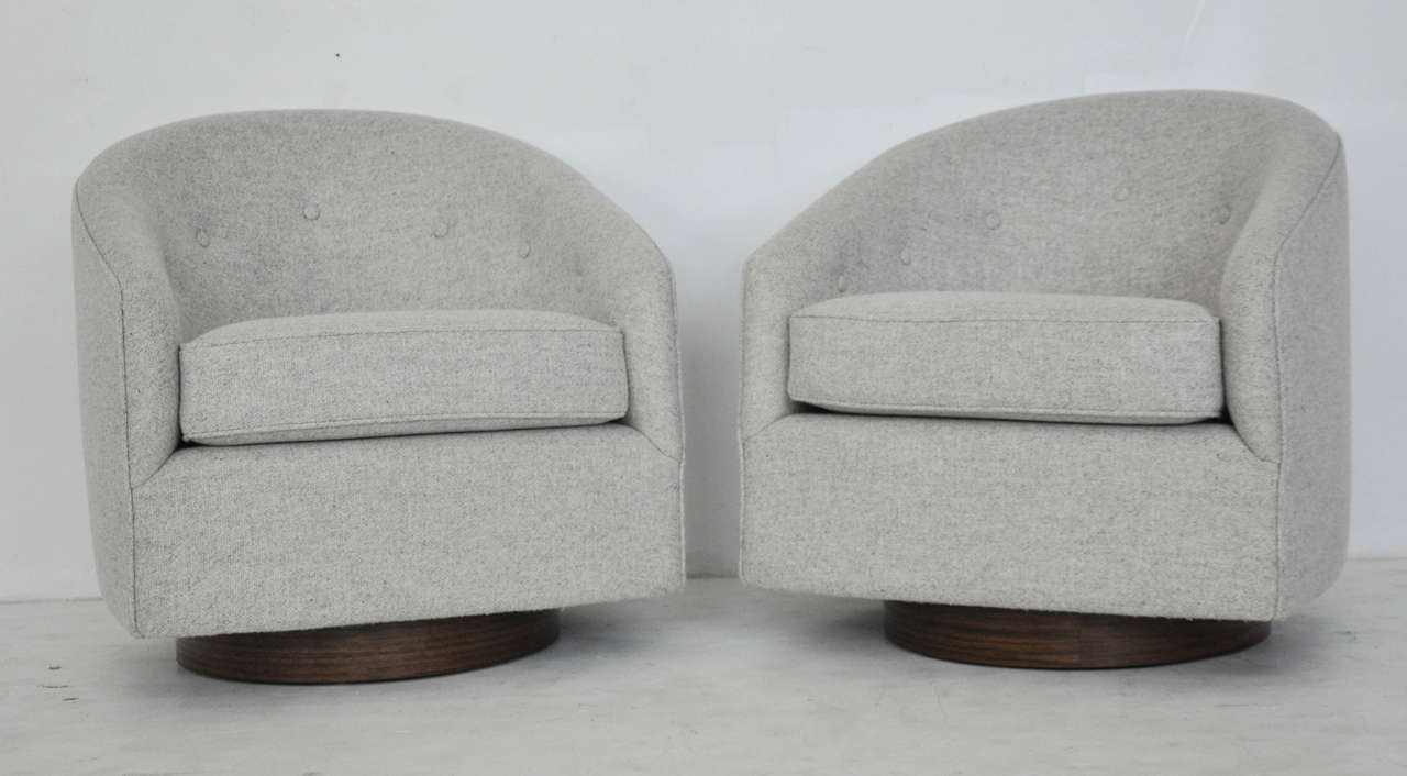 Pair of swivel lounge chairs by Milo Baughman.  Fully restored.  Walnut bases with wool upholstery.