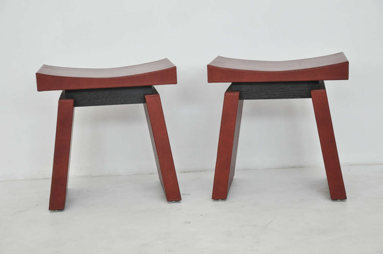 Chic pair of hand-stitched red leather stools by Dominic Chambon.  Paris, circa 1970s.