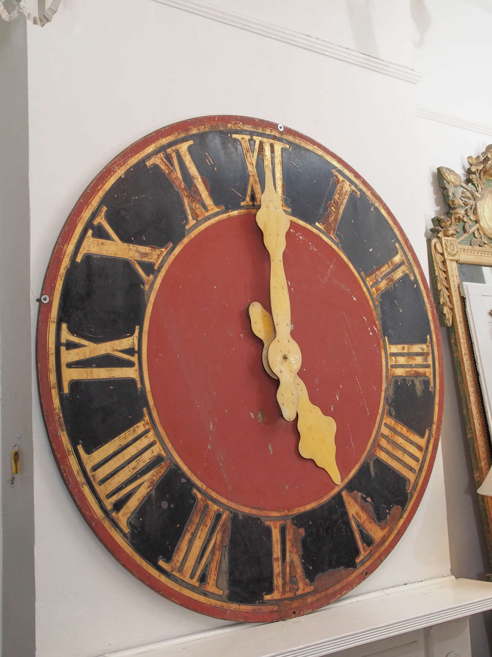 19th century very large iron clock painted in black, gold, yellow and red. Contemporary use as a wall decoration. No functioning mechanism.