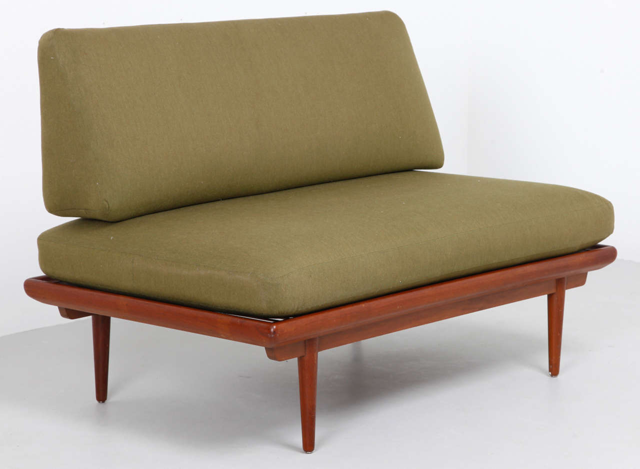 This a Danish Modern sofa/daybed by Peter Hvidt. It has a teak frame  and firm cushions upholstered in navy green wool. Great condition with vintage wear.